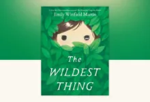 Book cover of The Wildest Thing by Emily Winfield Martin — a child's face peeking through green leaves