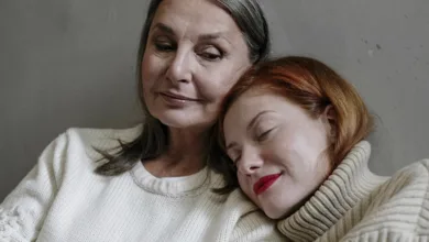 Adult daughter resting on mother's shoulder, sharing a quiet moment of connection at home