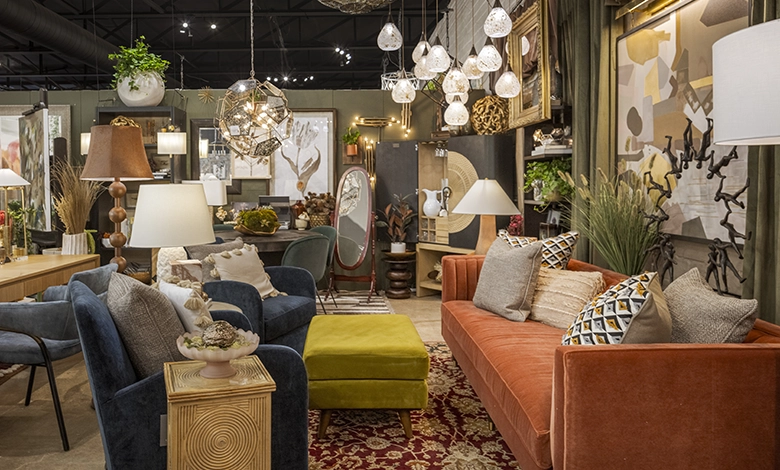 "Beautifully styled designer room vignette by Living Luxury Lab by MxD Interiors at The STUDIO Dallas featuring an orange velvet sofa, blue armchairs, layered lighting and one-of-a-kind décor"