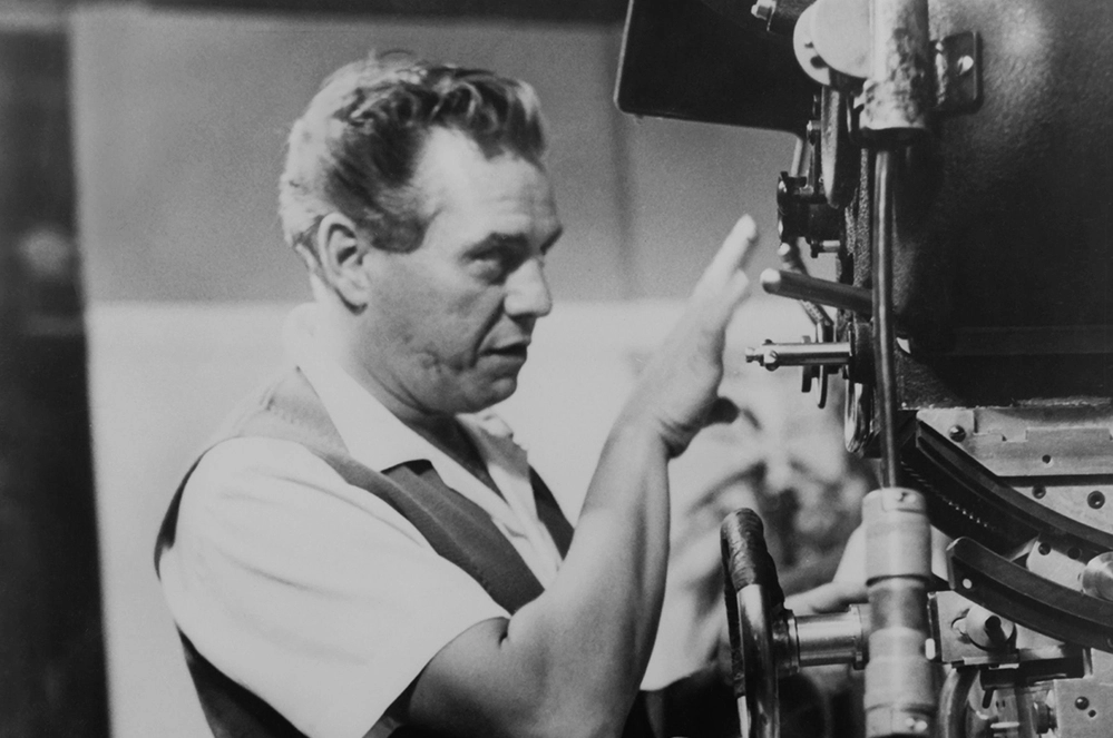 Desi Arnaz as executive producer examining a camera on the I Love Lucy set at Desilu Productions