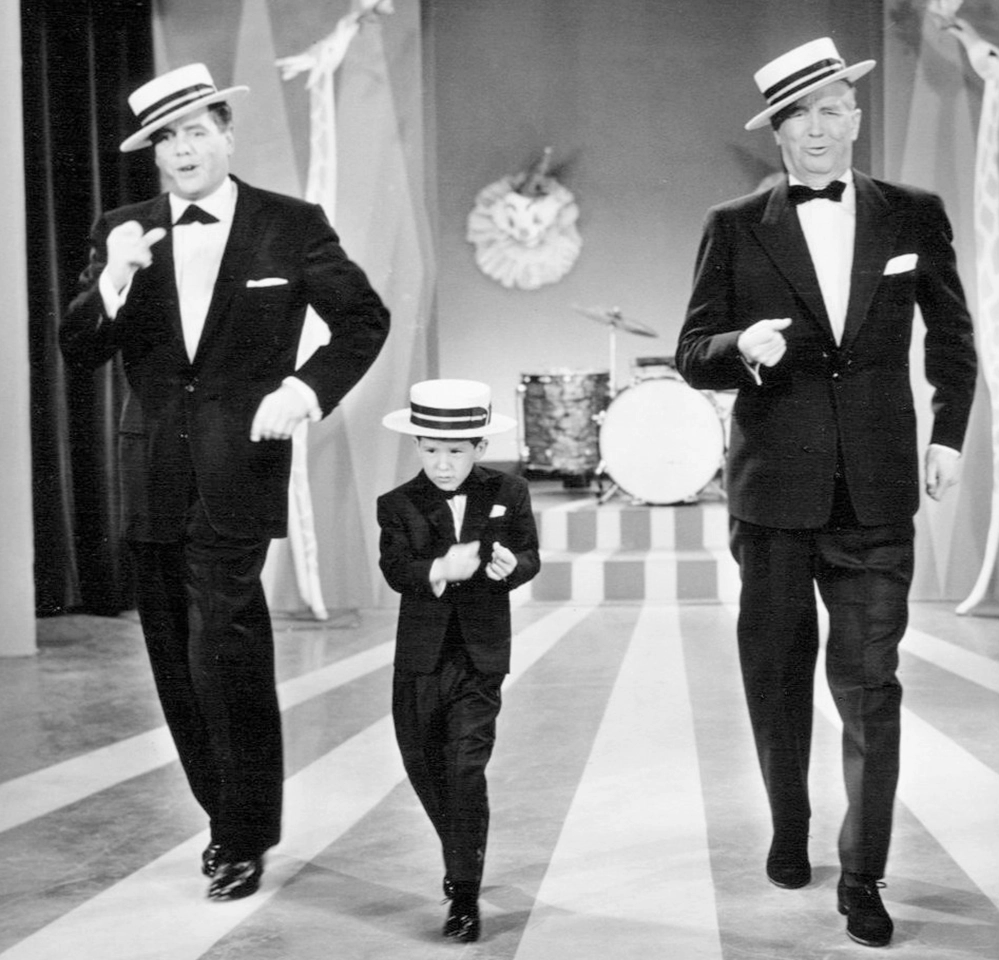 Desi Arnaz, child actor Richard Keith, and Maurice Chevalier in matching tuxedos and boater hats performing in the Lucy Goes to Mexico episode, 1958