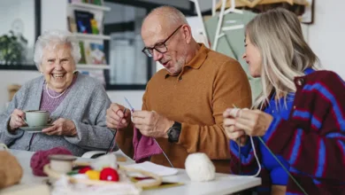 Older adults in a knitting class, one man focused on his stitches — staying curious is the secret to happiness after 50