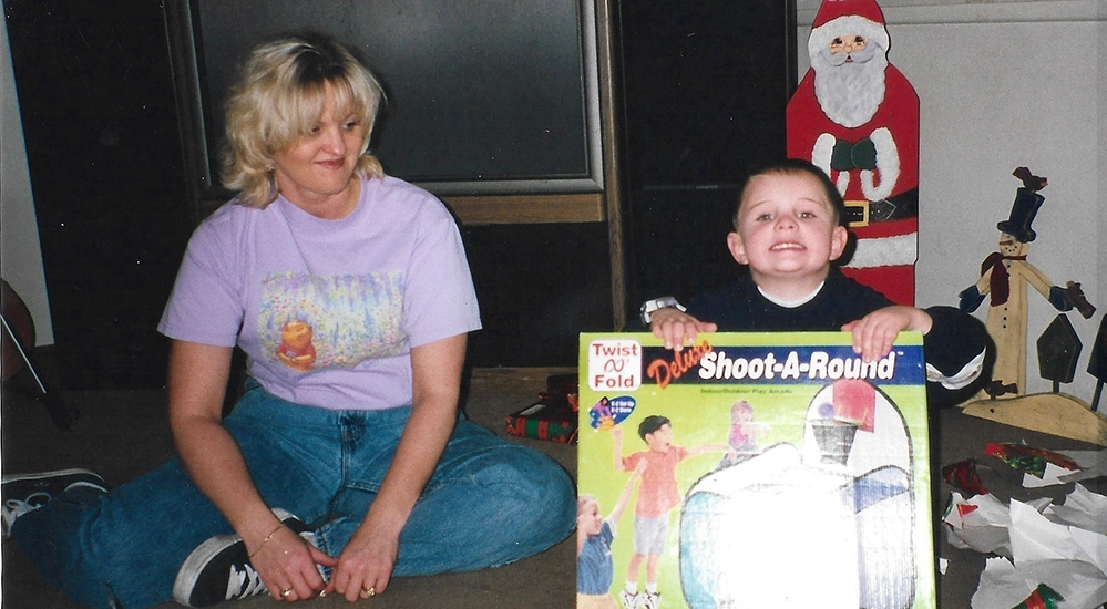 Young Tammy France sitting on the floor with her son Justin as a small boy at Christmas