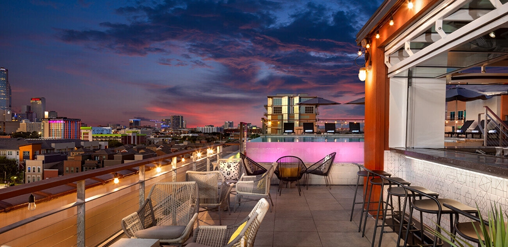 DARTable Sips: The Best Bars and Rooftops You Can Reach on DART This Summer 2 Rooftop patio bar at the Canvas Hotel in the Cedars neighborhood with panoramic views of the downtown Dallas skyline at night