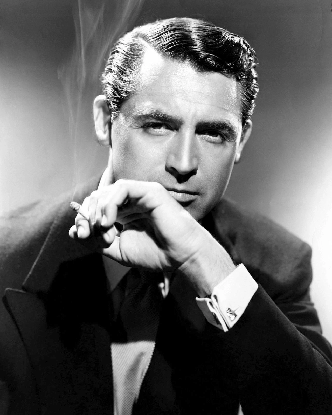 Black-and-white 1940s studio publicity portrait of Cary Grant in a dark suit.
