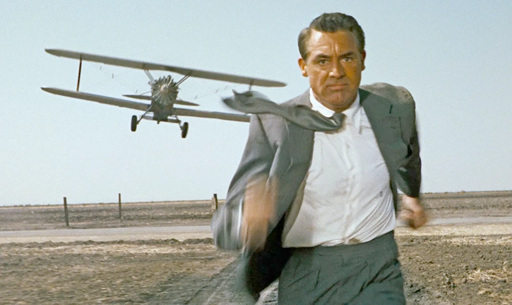 Cary Grant raising both hands in the crop-duster scene from North by Northwest, 1959.