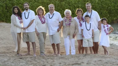 Baby Boomers Trade Inheritance for Unforgettable Family Trips 1 A multigenerational family posing on the beach at sunset in Hawaii