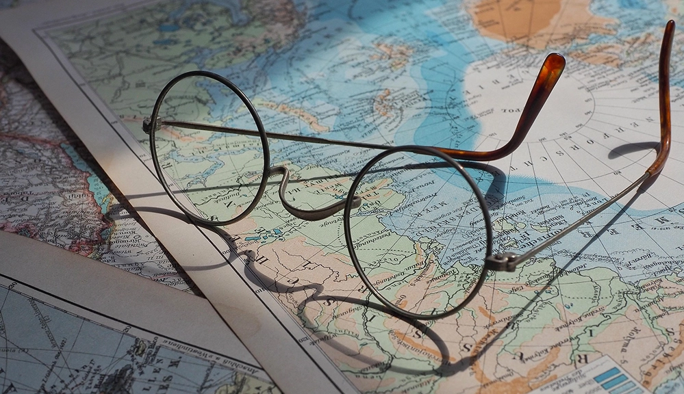 Vintage eyeglasses resting on an old-world map 