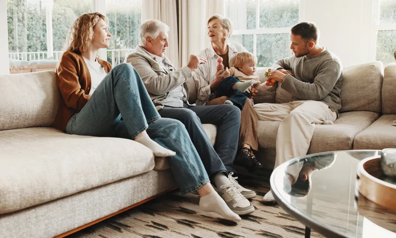 Grandparents, adult children and a baby together in a living room