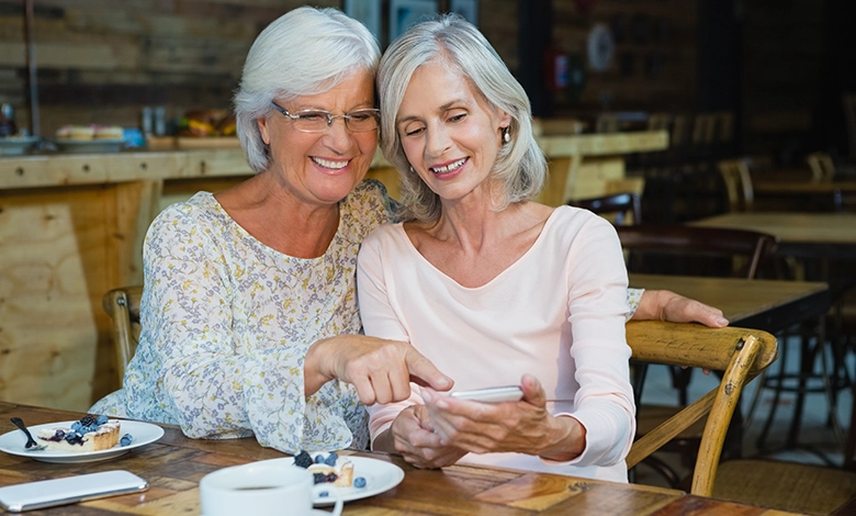 Two old friends catching up over coffee in a cafe, laughing and sharing stories
