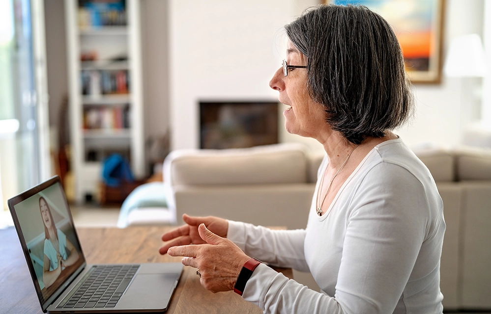 Older woman on a video call with her granddaughter, mid-conversation