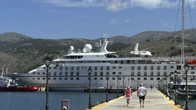 Windstar Star Legend docked at a Mediterranean pier with two passengers walking toward the ship