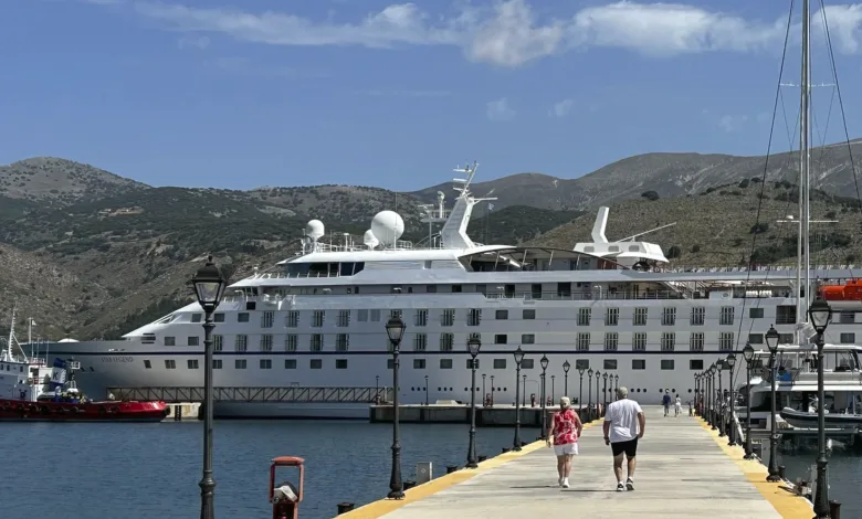 Windstar Star Legend docked at a Mediterranean pier with two passengers walking toward the ship